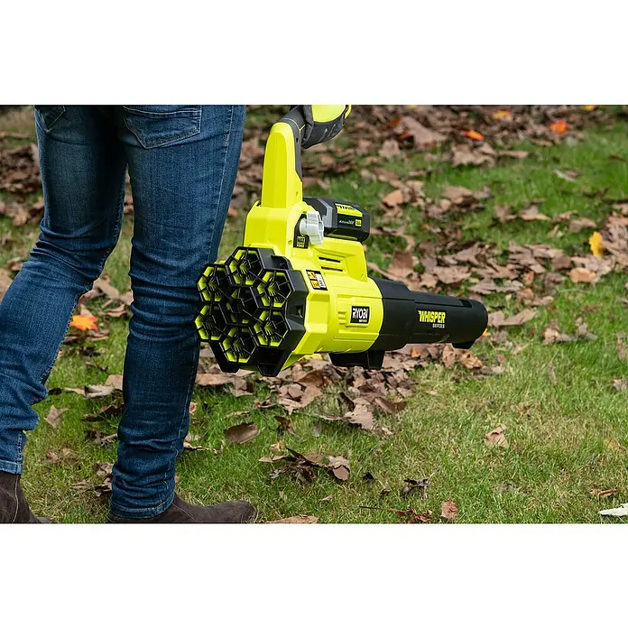 Ryobi Max Power Akku-Laubbläser RY36BLXA-0 - 36 V, Ohne Akku, Blasgeschwindigkeit: 176 km/h, Blasleistung: 15,6 m³/min - Nahaufnahme eines gelben und schwarzen Ryobi Laubbläsers, der über einem Rasen mit Blättern gehalten wird.