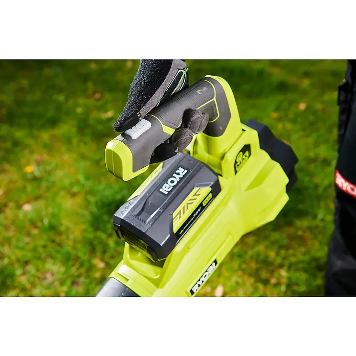 Ryobi Max Power Akku-Laubbläser RY36BLXA-0 - 36 V, Ohne Akku, Blasgeschwindigkeit: 176 km/h, Blasleistung: 15,6 m³/min - Nahaufnahme eines RYOBI Laubbläsers mit Akku und einer Hand mit Handschuh, die den Griff hält.