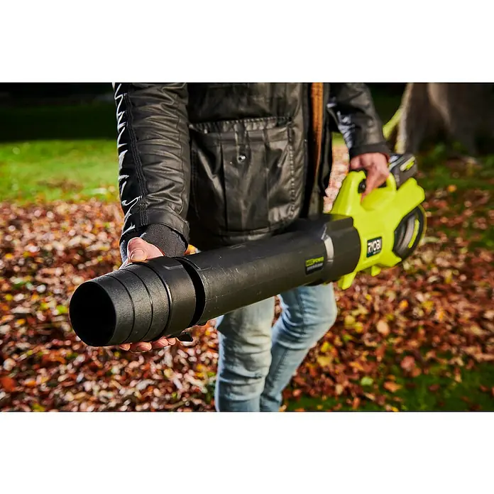 Ryobi Max Power Akku-Laubbläser RY36BLXB-0 - 36 V, Ohne Akku, Blasgeschwindigkeit: 306 km/h, Blasleistung: 20,67 m³/min - Eine Person hält einen gelb/schwarzen RYOBI Akku-Laubbläser vor einem Rasen mit Herbstlaub.