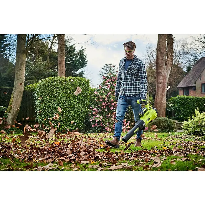 Ryobi Max Power Akku-Laubbläser RY36BLXA-0 - 36 V, Ohne Akku, Blasgeschwindigkeit: 176 km/h, Blasleistung: 15,6 m³/min - Mann im Garten mit dem RYOBI Laubbläser. Er bläst Blätter auf einem Rasen voller Herbstlaub.