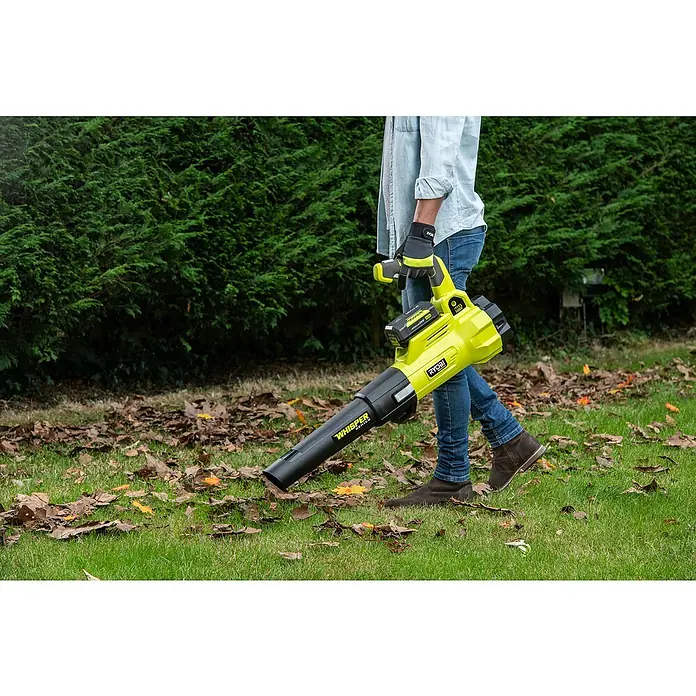 Ryobi Max Power Akku-Laubbläser RY36BLXA-0 - 36 V, Ohne Akku, Blasgeschwindigkeit: 176 km/h, Blasleistung: 15,6 m³/min - Eine Person bedient einen gelben Ryobi Laubbläser im Garten, um Laub zu entfernen. Das Gerät ist kabellos und für den einfachen Gebrauch konzipiert.