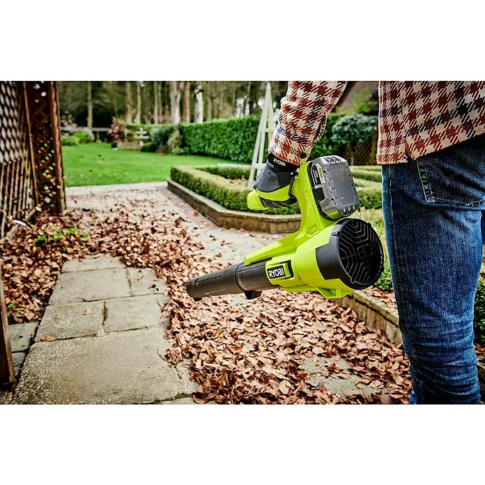 Ryobi ONE+ Akku-Laubbläser RY18BLA-0 - 18 V, Ohne Akku, Blasgeschwindigkeit: 145 km/h, Blasleistung: 7,1 m³/min - Der Ryobi Laubbläser mit Akku wird zum Entfernen von Herbstlaub auf einem gepflasterten Weg verwendet. Ideal für Gartenarbeiten.