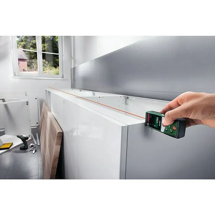 Bosch Medidor de distancia láser PLR 30 C - Gama de medición: 0,05 m - 30 m - Medidor láser de distancia Bosch PLR 30 C utilizado para medir una habitación, asegurando mediciones precisas para reformas de cocina.