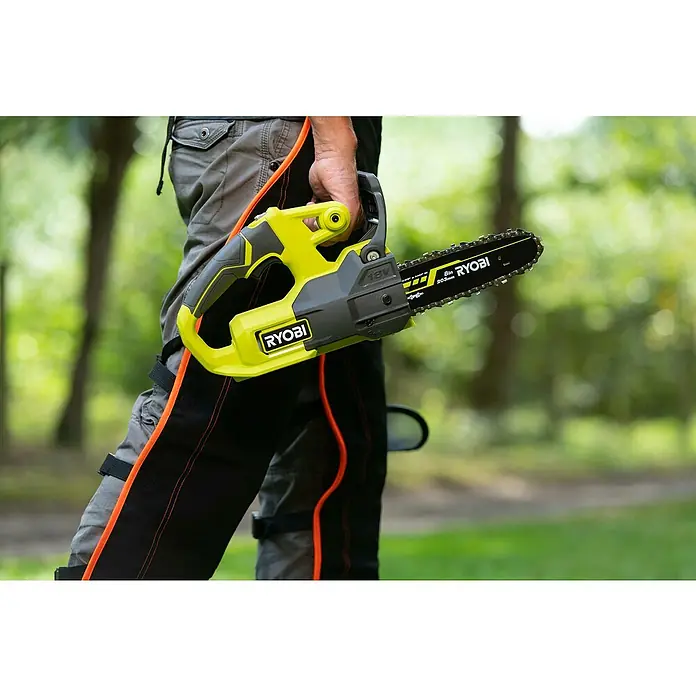 Ryobi ONE+ Maschinenpaket - Akku-Kettensäge RY18CS20A-0,18V, 4 Ah Akku & 2A Ladegerät - Nahaufnahme einer RYOBI Akku-Kettensäge in der Hand eines Mannes im Freien.