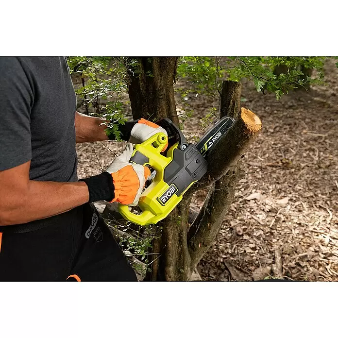 Ryobi ONE+ Maschinenpaket - Akku-Kettensäge RY18CS20A-0,18V, 4 Ah Akku & 2A Ladegerät - Eine Person mit Handschuhen verwendet eine gelb-schwarze Ryobi Kettensäge, um einen Ast zu sägen.