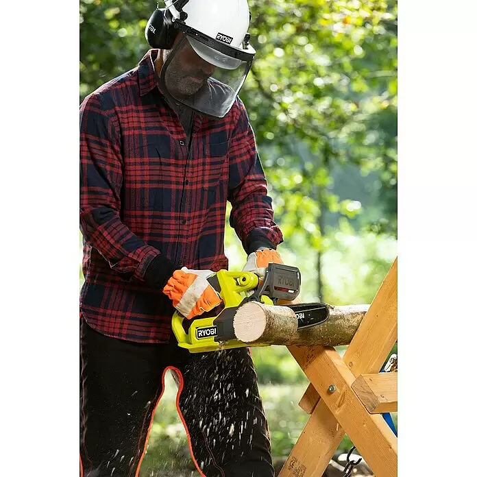 Ryobi ONE+ Akku-Kettensäge RY18CS20A-0 - 18 V, Li-Ionen, Ohne Akku, Schwertlänge: 20 cm - Eine Person in Schutzausrüstung sägt mit einer gelb-schwarzen RYOBI Kettensäge ein Holzscheit auf einem Sägebock, Sägespäne fliegen.