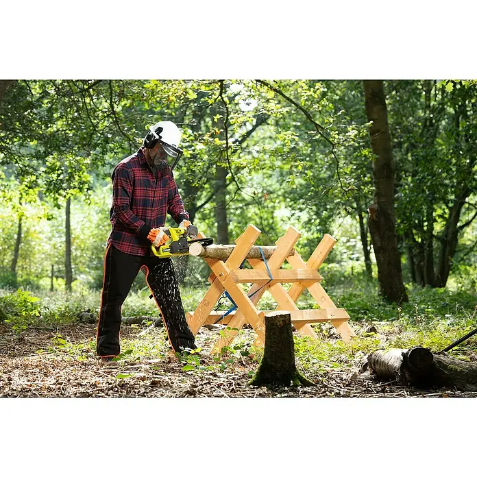 Ryobi ONE+ Akku-Kettensäge RY18CS20A-0 - 18 V, Li-Ionen, Ohne Akku, Schwertlänge: 20 cm - Eine Person, die eine Ryobi-Kettensäge benutzt, um ein Stück Holz zu zersägen, während sie Sicherheitsausrüstung in einer Waldumgebung trägt.