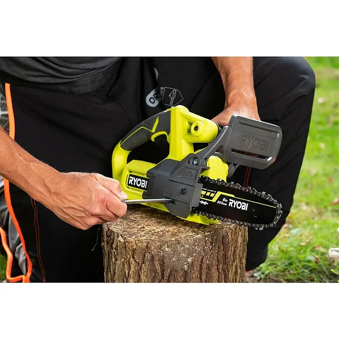 Ryobi ONE+ Maschinenpaket - Akku-Kettensäge RY18CS20A-0,18V, 4 Ah Akku & 2A Ladegerät - Der Ryobi Akku-Astkettensäge wird auf einem Baumstumpf mit einem Werkzeug eingestellt, um die Kettenspannung zu optimieren.