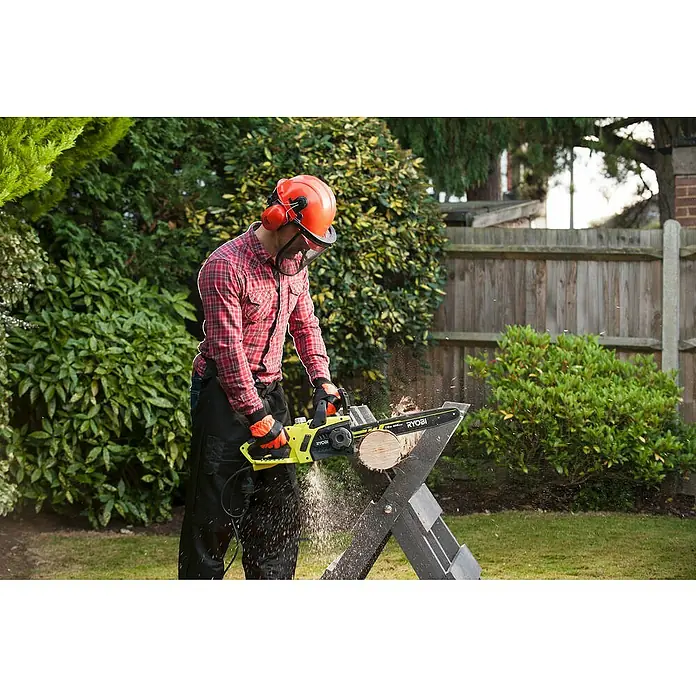 Ryobi Elektro-Kettensäge RCS2340B - 2.300 W, Schwertlänge: 40 cm - Ein Mann, der mit einer gelben Ryobi Kettensäge ein Holzstück auf einem Sägebock zersägt, während er Schutzkleidung trägt.
