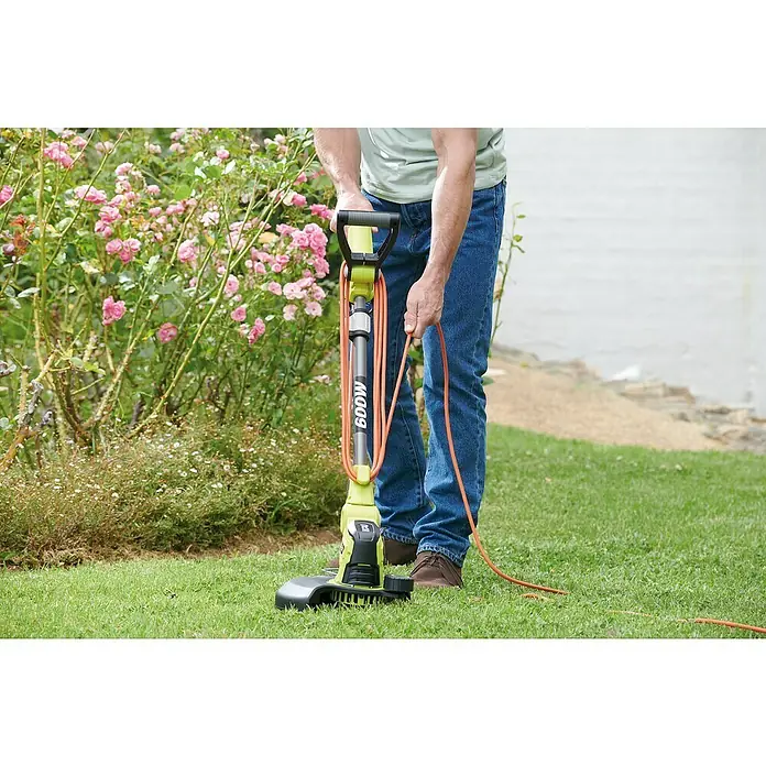 Ryobi Elektro-Rasentrimmer RLT6130 - 600 W, Schnittbreite Faden: 30 cm - Ein Mann benutzt einen Rasenkantenschneider der Marke Sun Joe 600W in seinem Garten, um die Rasenkanten zu pflegen.