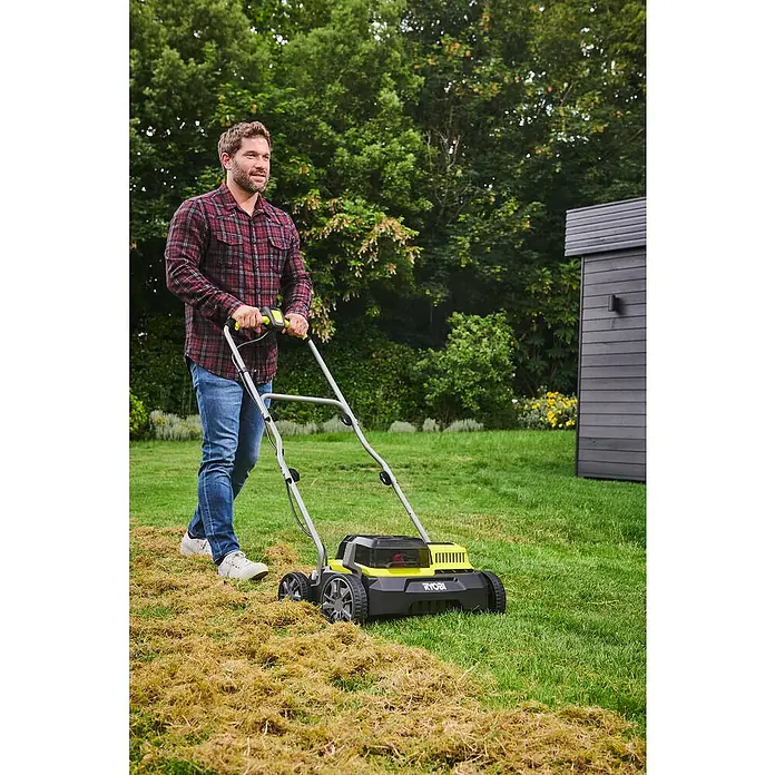 Ryobi ONE+ Escarificador de batería RY18SFX35A-0 - Número de baterías: Sin batería, 18 V, Anchura de trabajo: 35 cm - Un hombre está usando un escarificador Ryobi amarillo y negro en el jardín para mantener el césped.