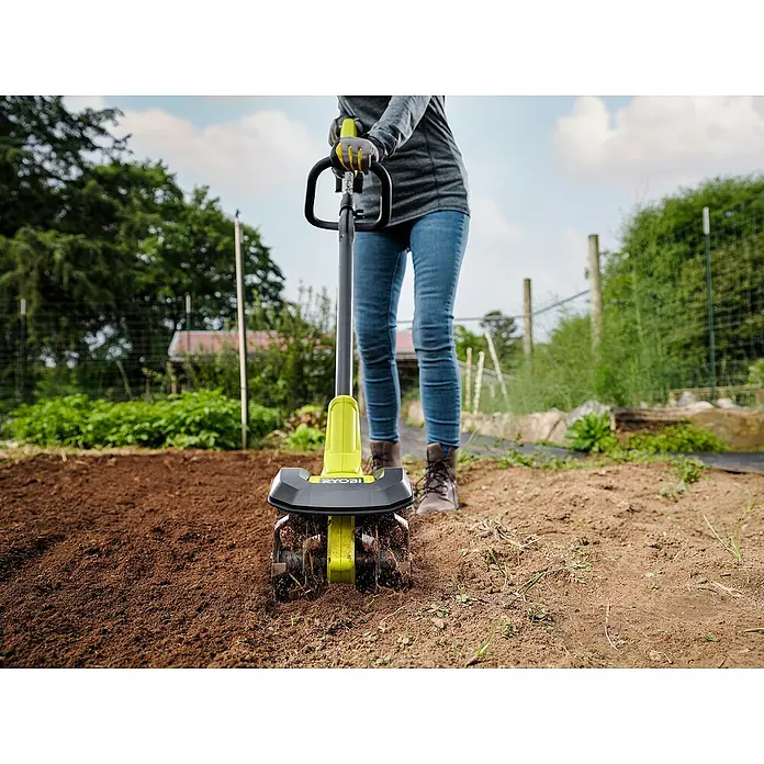 Ryobi ONE+ Akku-Bodenhacke RY18CVA-0 - Ohne Akku, Li-Ionen, 18 V - Eine Person benutzt einen RYOBI-Kultivator im Garten, um den Boden aufzulockern und für die Bepflanzung vorzubereiten.
