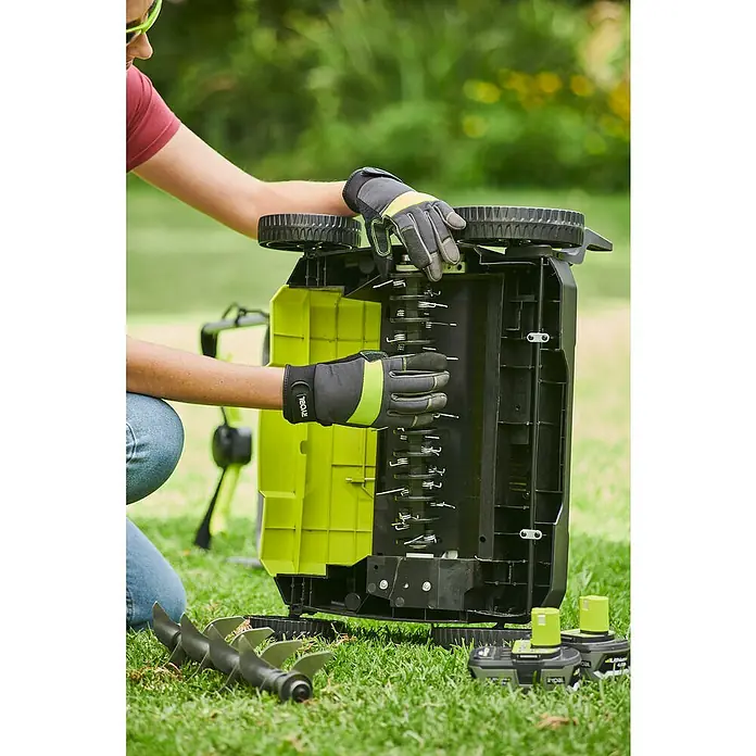 Ryobi ONE+ Akku-Vertikutierer RY18SFX35A-0 - Anzahl Akkus: Ohne Akku, 18 V, Arbeitsbreite: 35 cm - Nahaufnahme eines Ryobi-Rasenlüfters, der von einer Person mit Handschuhen bedient wird, mit Fokus auf Details des Geräts.