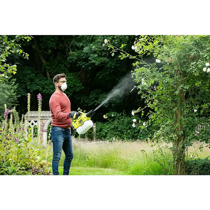Ryobi ONE+ Akku-Sprühgerät RY18FGA-0 - 18 V, Anzahl Akkus: Ohne Akku - Ein Mann, der einen Akku-betriebenen RYOBI-Zerstäuber benutzt, um weiße Blütenbüsche im Garten zu besprühen, geschützt mit Maske und Schutzbrille.