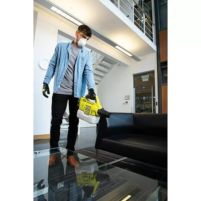 Ryobi ONE+ Akku-Sprühgerät RY18FGA-0 - 18 V, Anzahl Akkus: Ohne Akku - Eine Person in Schutzkleidung hält einen gelb-weißen RYOBI 18V Vernebler/Sprühgerät, bereit zum Einsatz in Innenräumen.