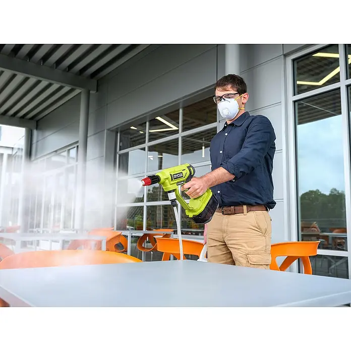 Ryobi ONE+ Druckreiniger Kaltverneblungsdüsen-Set RAC754 - Passend für: Alle Ryobi 18 V Mitteldruckreiniger - Mann desinfiziert Tisch mit RYOBI elektrostatischem Sprühgerät, das für eine effektive Reinigung entwickelt wurde. Ideal für den gewerblichen Gebrauch.