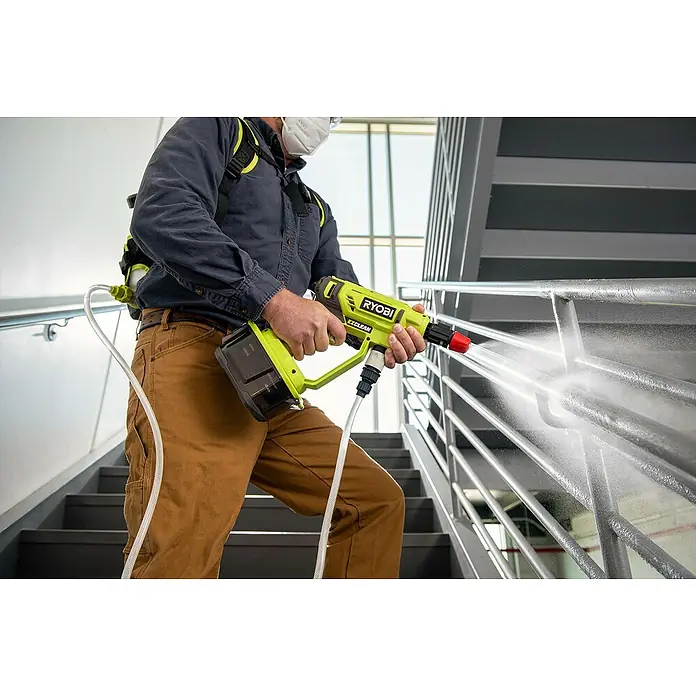 Ryobi ONE+ Druckreiniger Kaltverneblungsdüsen-Set RAC754 - Passend für: Alle Ryobi 18 V Mitteldruckreiniger - Ein Mann reinigt ein Treppengeländer mit einem RYOBI EZCLEAN Akku-Reiniger. Der Reiniger ist grün und schwarz.