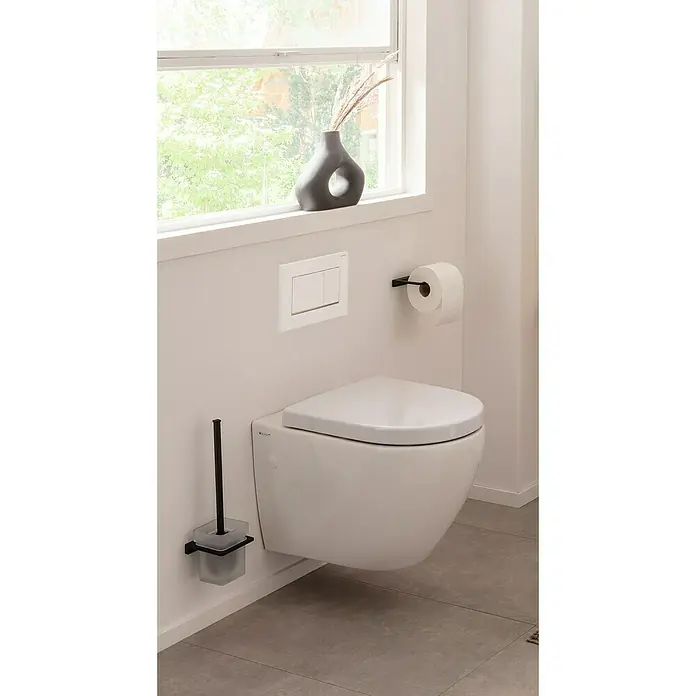 Phoenix Toilettenpapierhalter - Ohne Deckel, Schwarz, Matt - Ein modernes Badezimmer mit einer wandhängenden Toilette, einem Toilettenpapierhalter und einer Vase auf der Fensterbank.