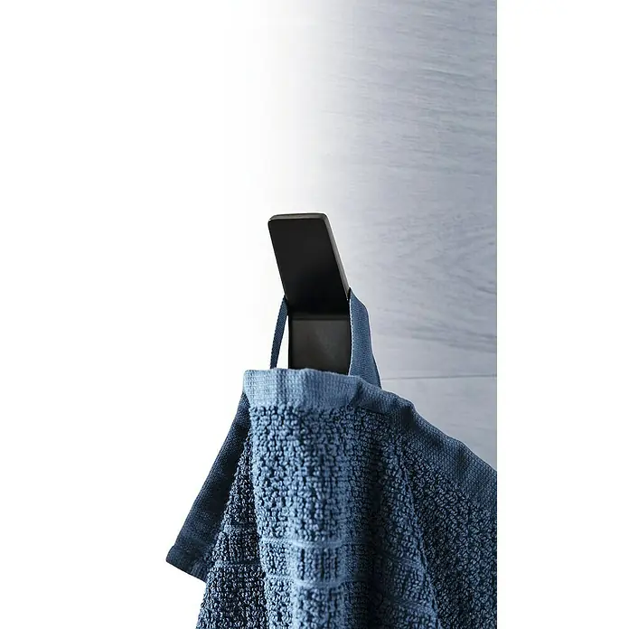 Phoenix Handtuchhaken - 1 Stk., Schwarz, Matt - Nahaufnahme eines modernen Handtuchhalters mit einem blauen Handtuch, der an einer hellen Holzwand hängt. Elegantes Badezimmer-Accessoire.