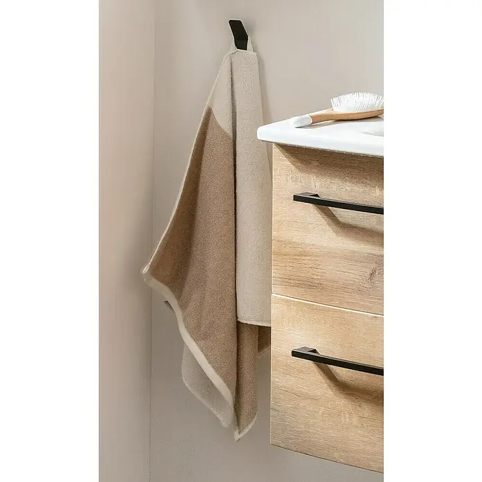 Phoenix Handtuchhaken - 1 Stk., Schwarz, Matt - Ein beiger Handtuch hängt an einem Haken im Badezimmer. Eine Bürste liegt auf der Ablage neben dem Handtuch.