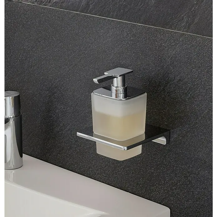 Lanzet Seifenspender - Metall, Chrom - Ein quadratischer, matter Seifenspender mit verchromter Pumpe steht auf einer glänzenden Halterung an einer dunklen Wand über einem Waschbecken.