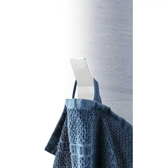 Phoenix Handtuchhaken - 1 Stk., Chrom, Glänzend - Detailaufnahme eines blauen Handtuchs, das an einem transparenten Haken vor einer Wand hängt, Fokus auf Textur und Aufhängung.