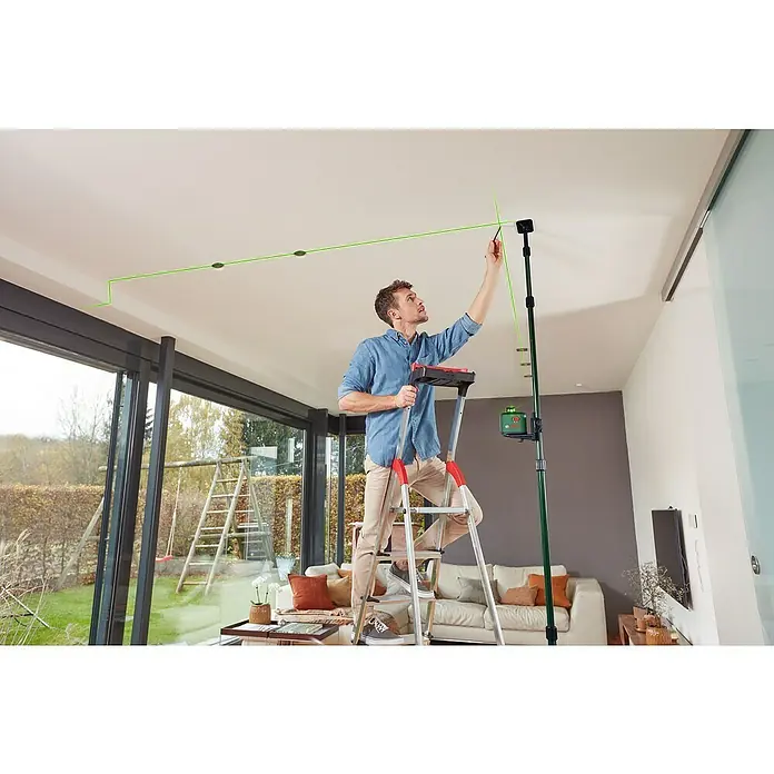 Bosch Teleskopstange TP 320 - Kunststoff, Arbeitshöhe: 10 cm - 320 cm - Mann mit Bosch Laser-Nivelliergerät auf einer Leiter, der eine grüne Laserlinie an der Decke markiert.