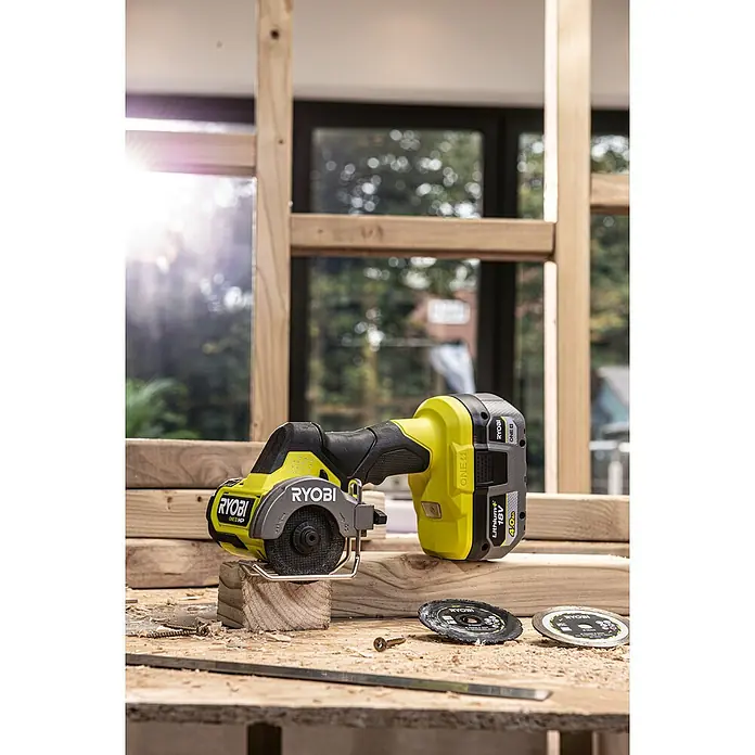 Ryobi ONE+HP Akku-Winkelschleifer RCT18C-0 - 18 V, Ohne Akku - Ein Ryobi ONE+ Akku-Multifunktionswerkzeug auf einem Holztisch mit Zubehör, ideal für Heimwerkerprojekte.