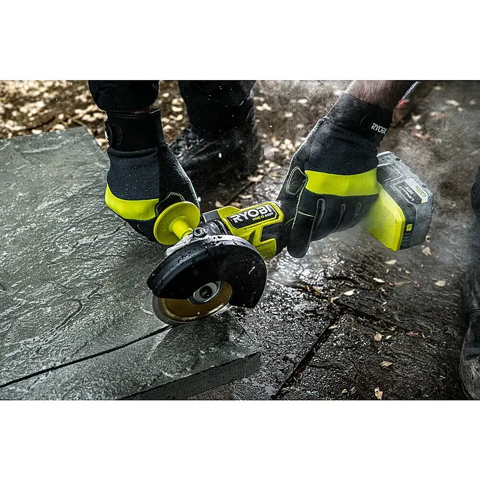 Ryobi ONE+HP Akku-Winkelschleifer RAG18X-0 Performance - Ohne Akku, Durchmesser Scheibe: 125 mm - Nahaufnahme eines Ryobi ONE+ HP Winkelschleifers mit Akku, der eine Steinplatte schneidet, wobei der Fokus auf dem Werkzeug liegt.