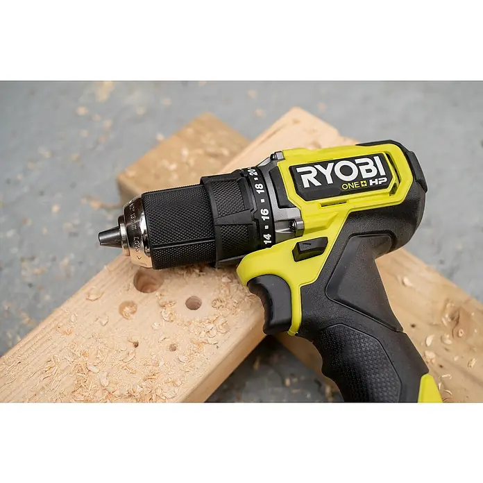 Ryobi ONE+HP Akku-Bohrschrauber RDD18C-0 - 18 V, Ohne Akku, 54 Nm - Ein Ryobi ONE+ HP Akku-Bohrschrauber liegt auf einem Holzbrett mit Bohrlöchern und Holzspänen. Ideal für DIY-Projekte.