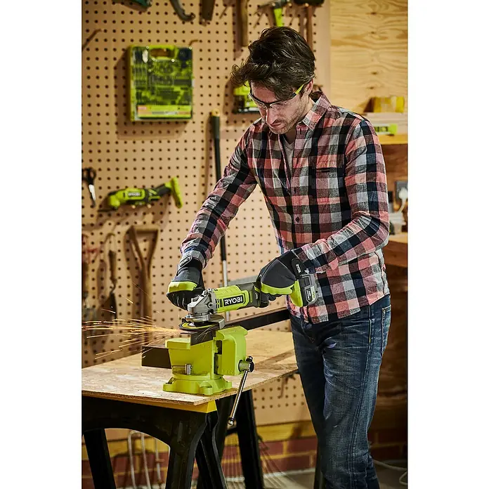 Ryobi ONE+ Akku-Winkelschleifer RAG18125-0 - Ohne Akku, Durchmesser Scheibe: 125 mm - Ein Mann benutzt einen Ryobi Winkelschleifer mit Akku in einer Werkstatt, um Metall zu schleifen, wobei Funken fliegen.