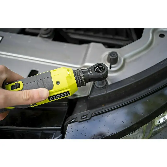 Ryobi ONE+ Akku-Ratschenschrauber R18RW2-0 - 18 V, Ohne Akku, ¼″ - Eine Nahaufnahme eines gelben und grauen Ryobi-Ratschenschraubers, der an einem schwarzen Fahrzeugteil befestigt ist.
