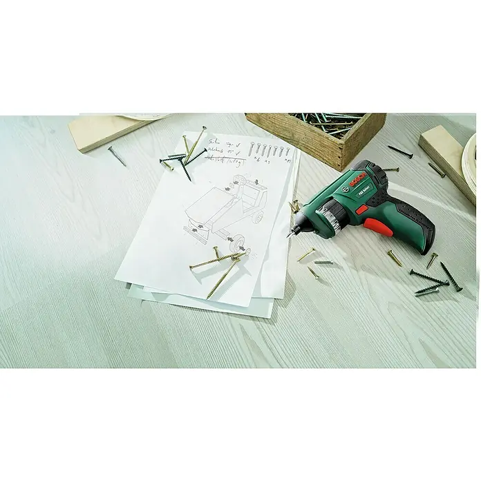 Bosch Akkuschrauber PSR Select - 3,6 V, 1 Akku, 1,5 Ah - Aufsicht auf einen grünen Bosch PSR Select Akku-Bohrschrauber auf einer Werkbank mit Schrauben und Bauplan.