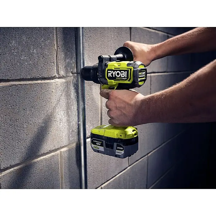 Ryobi ONE+HP Akku-Schlagbohrschrauber RPD18X-0 - 18 V, Ohne Akku, 95 Nm - Nahaufnahme eines Akku-Schlagbohrschraubers Ryobi ONE+ HP beim Bohren in eine Ziegelwand mit einer Person.