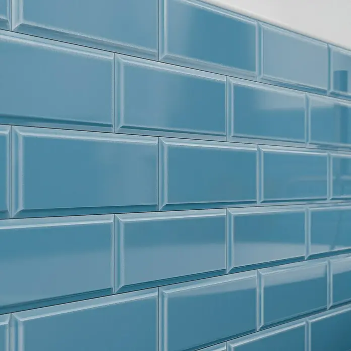 Modern Style Wandfliese Metro Biselado Azul 730 - 9,8 x 29,8 cm, Blau, Glänzend - Nahaufnahme einer Wand, die mit glänzenden, hellblauen Metrofliesen verkleidet ist, die ein sauberes und modernes Erscheinungsbild vermitteln.