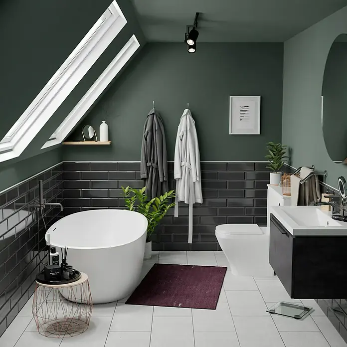 Modern Style Wandfliese Manhattan Biselado Cince 670 - 9,8 x 29,8 cm, Anthrazit, Glänzend - Das Badezimmer zeigt eine moderne Badewanne, dunkle Fliesen und stilvolle Armaturen, die ein elegantes Ambiente schaffen.
