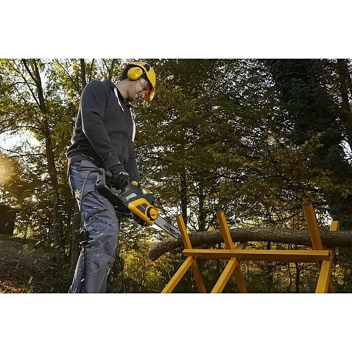 Stiga Elektro-Kettensäge CS 122c - 2.200 W, Schwertlänge: 40 cm - Ein Mann mit Schutzausrüstung verwendet eine gelb-schwarze Kettensäge, um Holz auf einem gelben Sägebock im Freien zu schneiden.