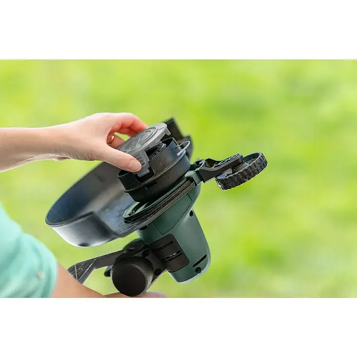Bosch Elektro-Bandschleifmaschine PBS 75 AE - 750 W - Eine Person setzt den Spulendeckel auf eine grüne Rasentrimmer-Spule.