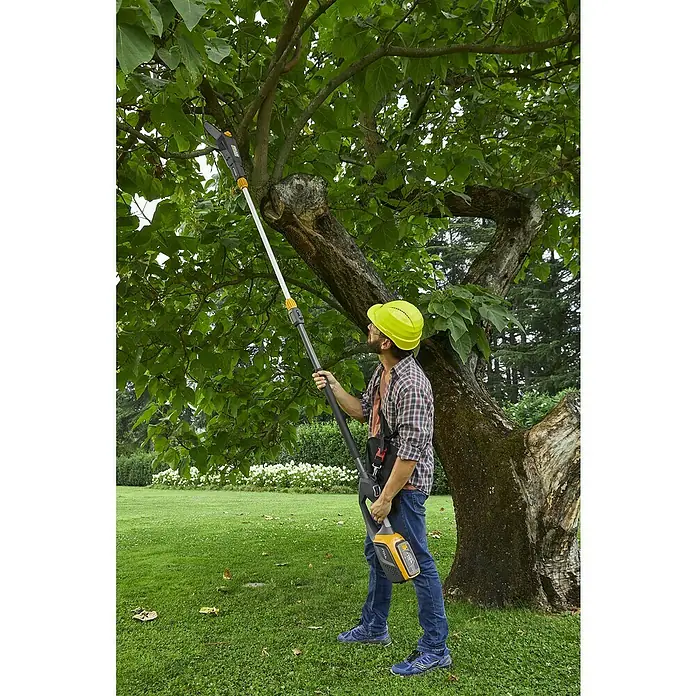 Stiga 500er Serie Akku-Multitool MT 500e - 48 V, Ohne Akku - Mann schneidet Baum mit Stiga Hochentaster. Das Gerät ist gelb, schwarz und weiß, und er trägt einen gelben Schutzhelm.