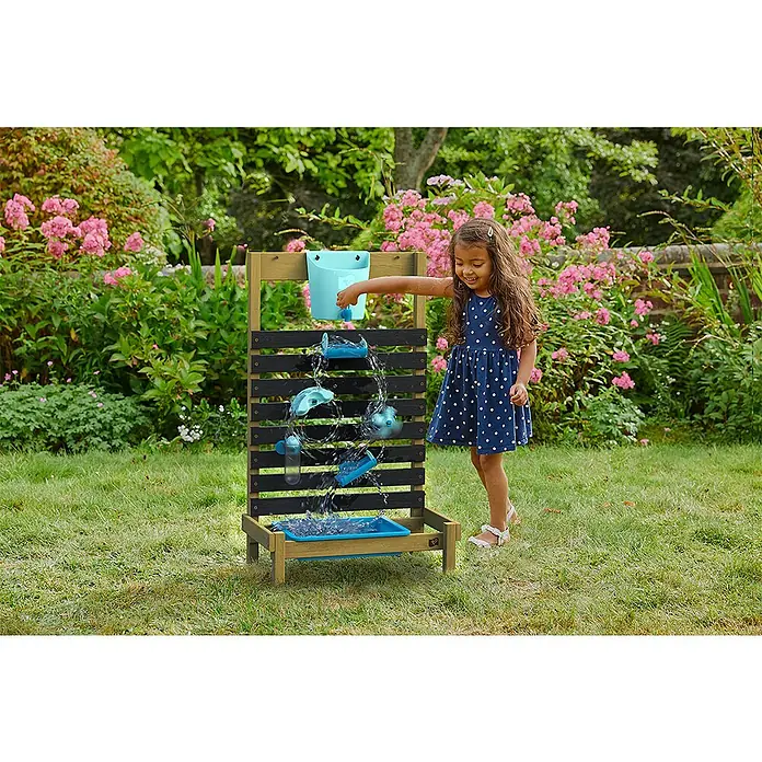 TP Toys Gartenspielgerät Splash - 31 x 57 x 92 cm, Holz - Ein Mädchen spielt mit einer Outdoor-Wasserspielstation aus Holz mit Becken und Zubehör im Garten.