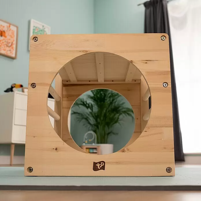 TP Toys Klettergerüst Active Tots Cube - 62 x 60 x 52 cm, Holz, Natur - Heller Holz-Aktivitätswürfel für Kinder mit kreisförmigem Ausschnitt, auf einer Spielmatte im Kinderzimmer.