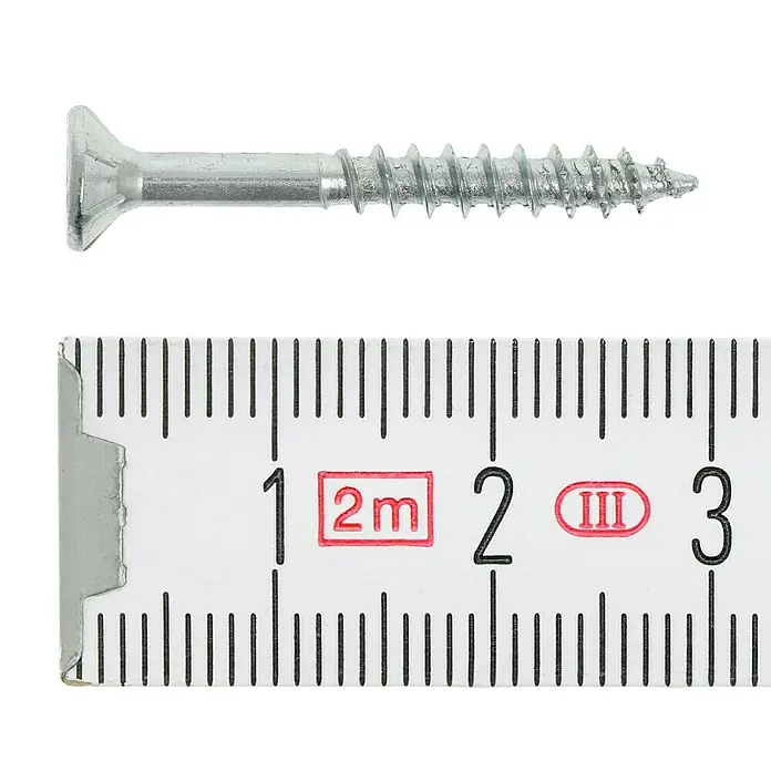 Profi Depot Tornillo para madera - Ø x L: 3,5 x 30 mm, 200 ud., Zincado, Ranura en forma de cruz Pozidriv - Primer plano de un tornillo de metal avellanado junto a una regla plegable, que muestra una longitud de aprox. 2,7 cm.