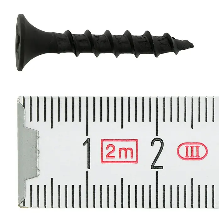 Profi Depot Schnellbauschraube - Durchmesser: 3,9 mm, Länge: 25 mm, Senkkopf, Grobgewinde, 1.000 Stk. - Nahaufnahme einer schwarzen Schnellbauschraube neben einem Messlineal zur Größenbestimmung.