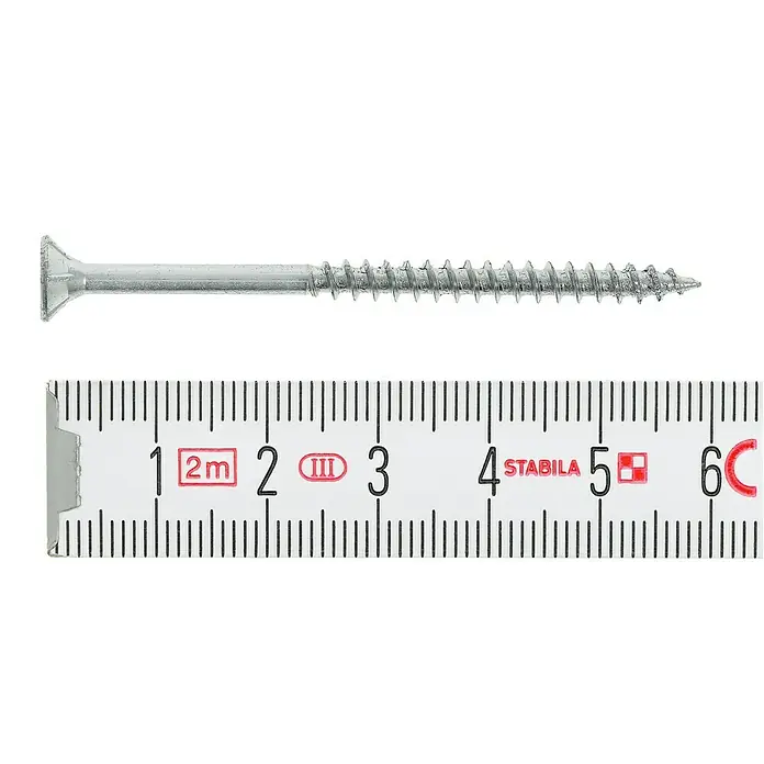 Profi Depot Spanplattenschraube VZ - Ø x L: 4 x 60 mm, 500 Stk., Verzinkt - Nahaufnahme einer Schraube, die neben einem Zollstock liegt. Das Produkt ist ca. 5,5 cm lang und hat einen flachen Kopf.