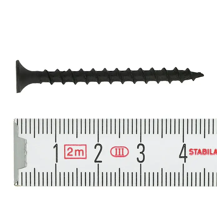 Profi Depot Schnellbauschraube - Durchmesser: 3,9 mm, Länge: 45 mm, Senkkopf, Grobgewinde, 500 Stk. - Ein schwarze Trockenbauschraube, die neben einem Zollstock liegt. Sie ist ca. 3,75 cm lang. Perfekt für Heimwerkerarbeiten.