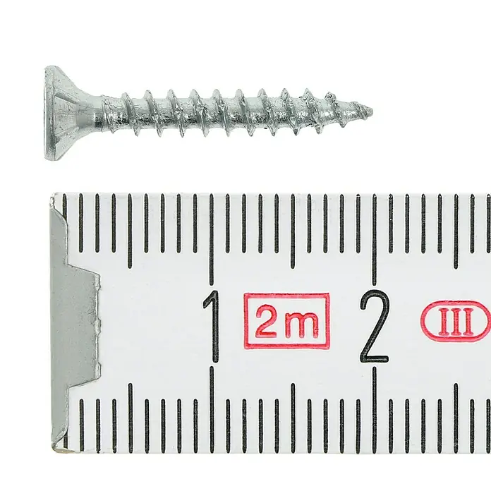 Profi Depot Tornillo para madera - Ø x L: 3 x 20 mm, 200 ud., Zincado, Ranura en forma de cruz Pozidriv - Primer plano de un tornillo avellanado con una cinta métrica para referencia de tamaño.