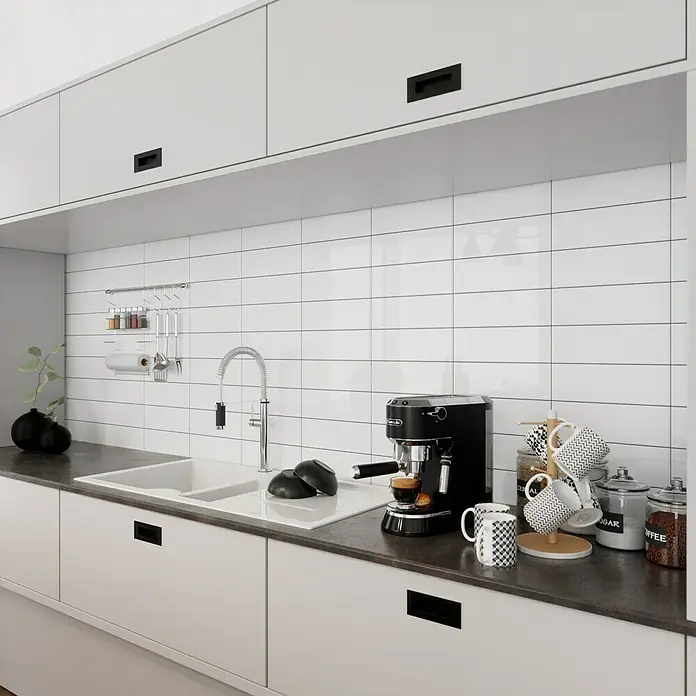 Modern Style Wandfliese Emotion Branco 500 - 9,8 x 29,8 cm, Weiß, Glänzend - Die Küche mit einer schwarzen Espressomaschine, Tassenhalter und Vorratsgläsern auf einer dunklen Arbeitsplatte mit Spüle und weißen Schränken.