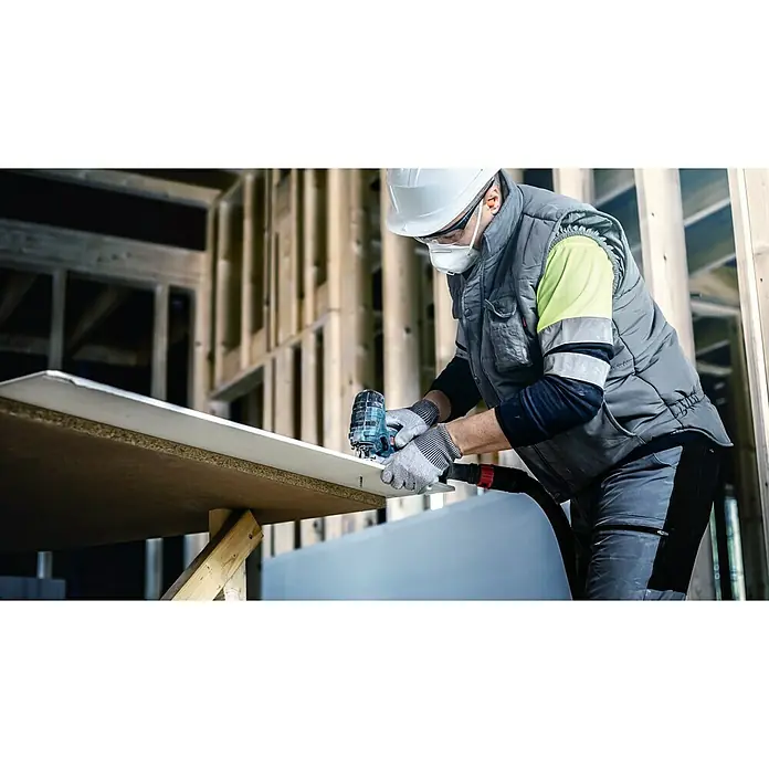 Bosch Expert Säbelsägeblatt Fiber Plaster T141 HM - Länge: 100 mm - Ein Bauarbeiter mit Schutzhelm und Schutzbrille schneidet eine Platte mit einer Stichsäge in einem Rohbau zu.