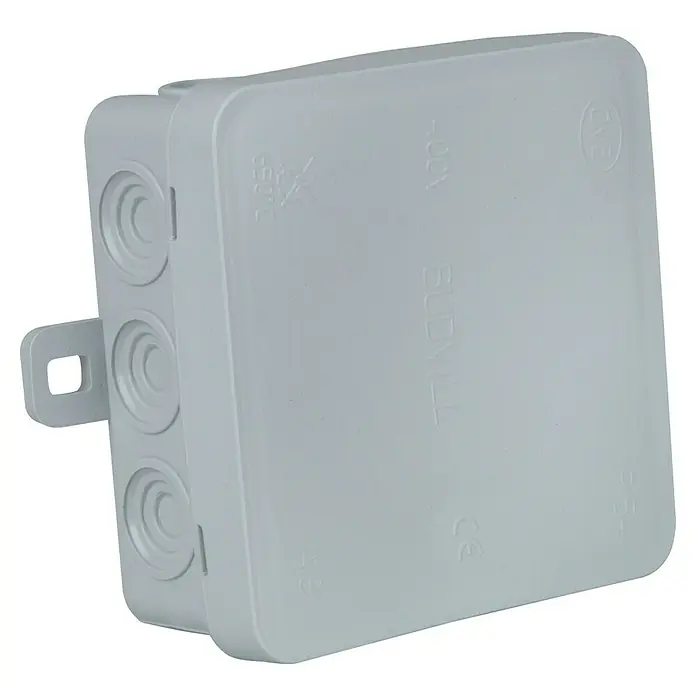 Abzweigdose - 85 x 85 x 40 mm, Aufputz - Eine graue Abzweigdose aus Kunststoff mit kreisförmigen Aussparungen und Montagehalterung für elektrische Verbindungen.