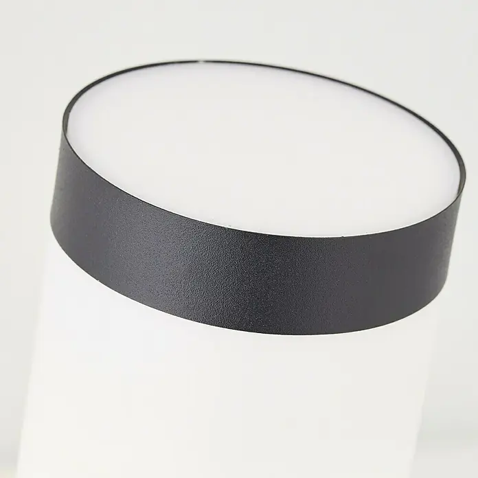 Brilliant Dody Sensor-Außenleuchte - 60 W, 17 x 7,6 x 40 cm, Schwarz, IP44 - Nahaufnahme einer runden Deckenleuchte mit schwarzem Rand und weissem Diffusor. Die Leuchte sorgt für eine gleichmäßige und angenehme Beleuchtung.